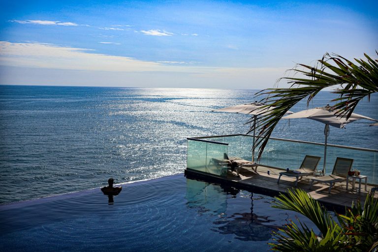 A large swimming pool next to the ocean