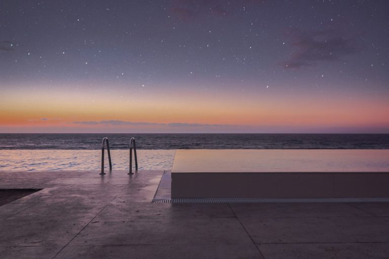 Silhouette of person standing on sea dock during sunset