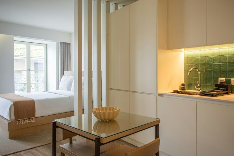 A room with a bed and a table with a bowl on it
