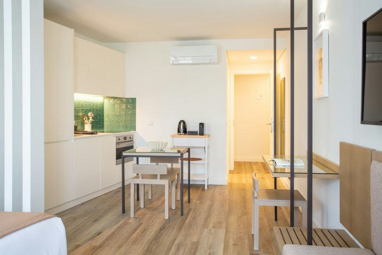 A room with a table, chairs and a television