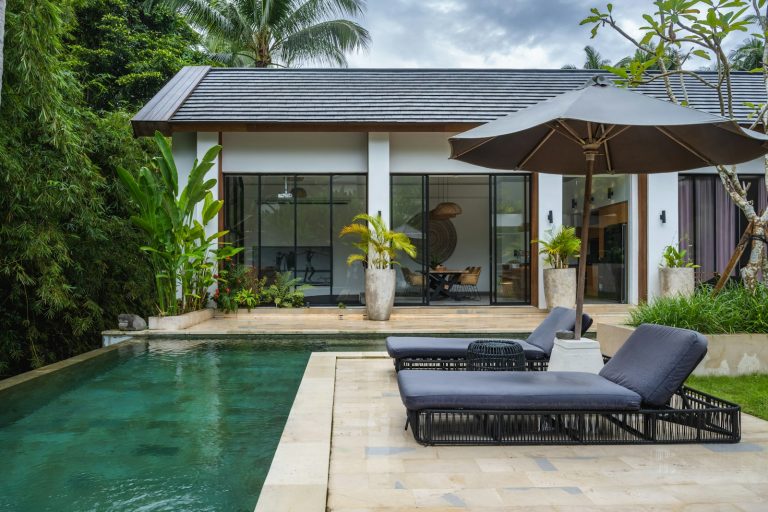 A couple of chaise lounge chairs sitting next to a pool