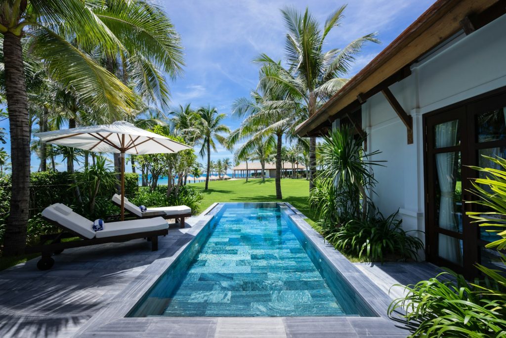 White and brown wooden house near swimming pool during daytime