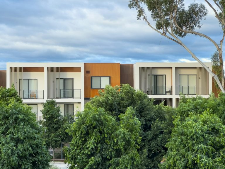 Modern apartment building with trees against a cloudy sky