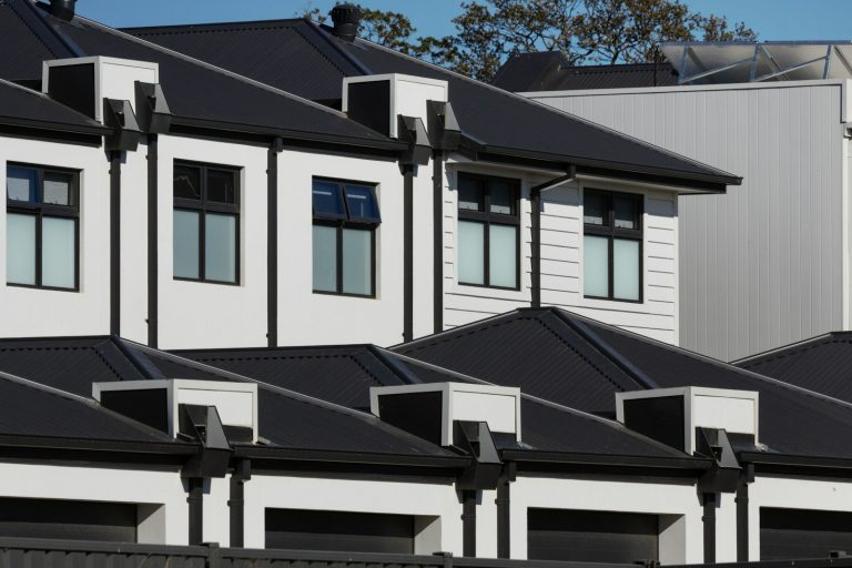 Row of modern white houses with black roofs